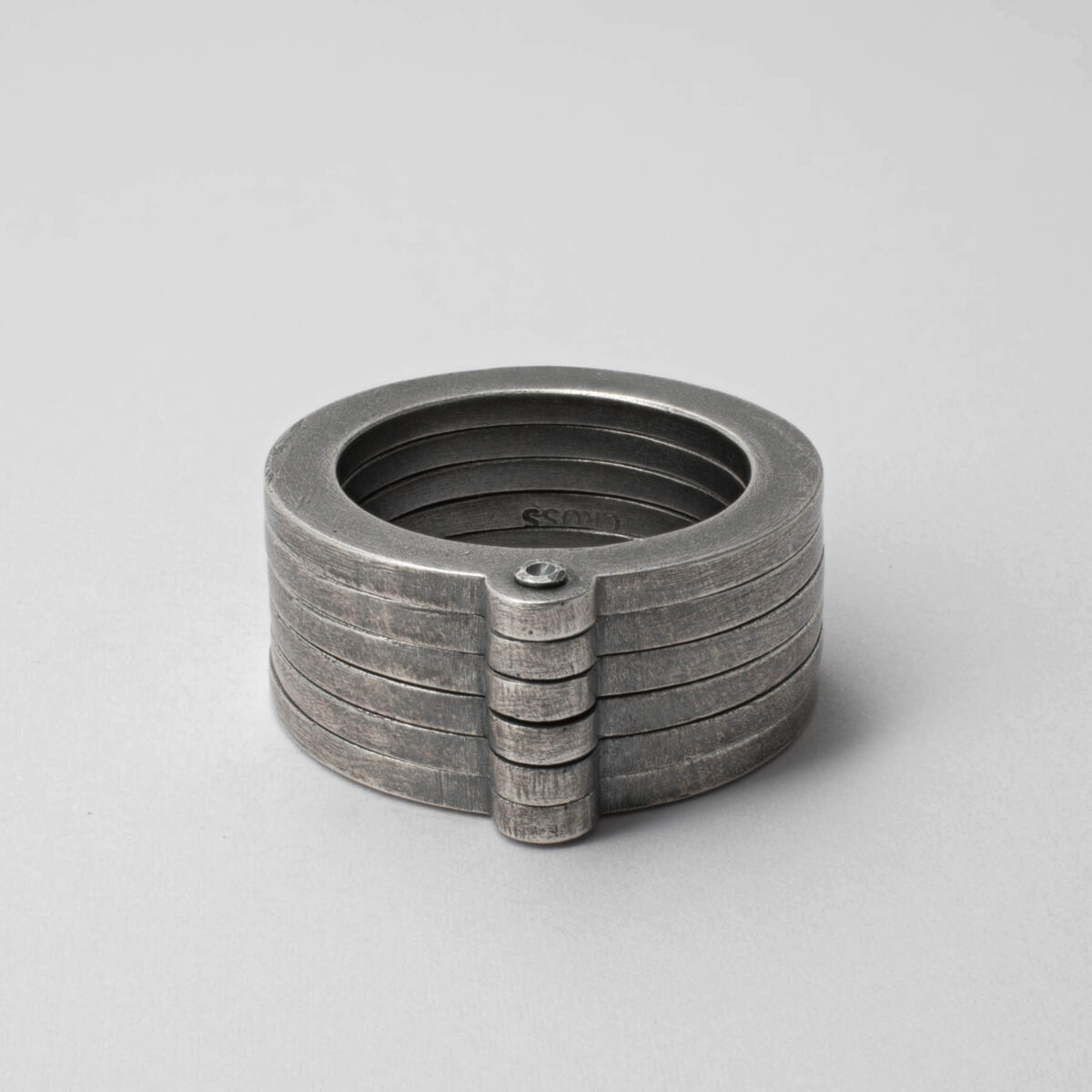 Stacked silver rings on gray background